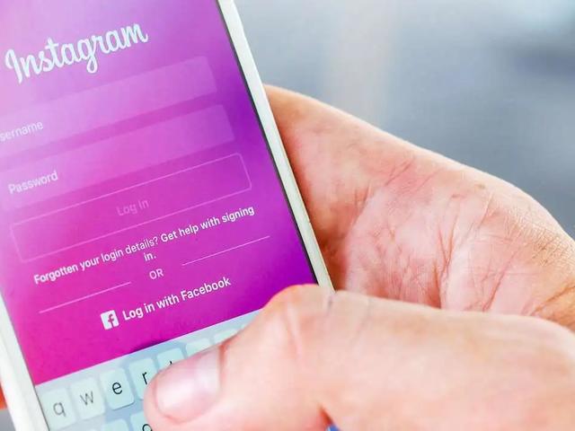 Una mano sostiene un teléfono con la pantalla de inicio de sesión de Instagram, con campos de usuario y contraseña