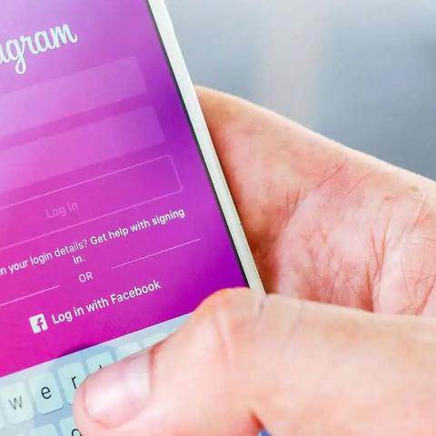 Una mano sostiene un teléfono con la pantalla de inicio de sesión de Instagram, con campos de usuario y contraseña