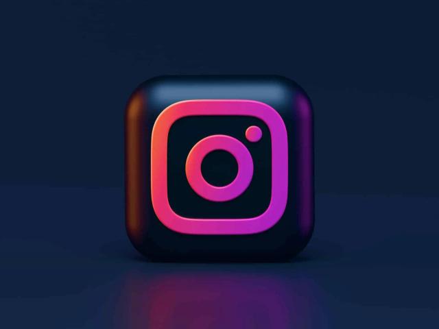 3D Instagram logo icon in pink and orange on a dark blue background