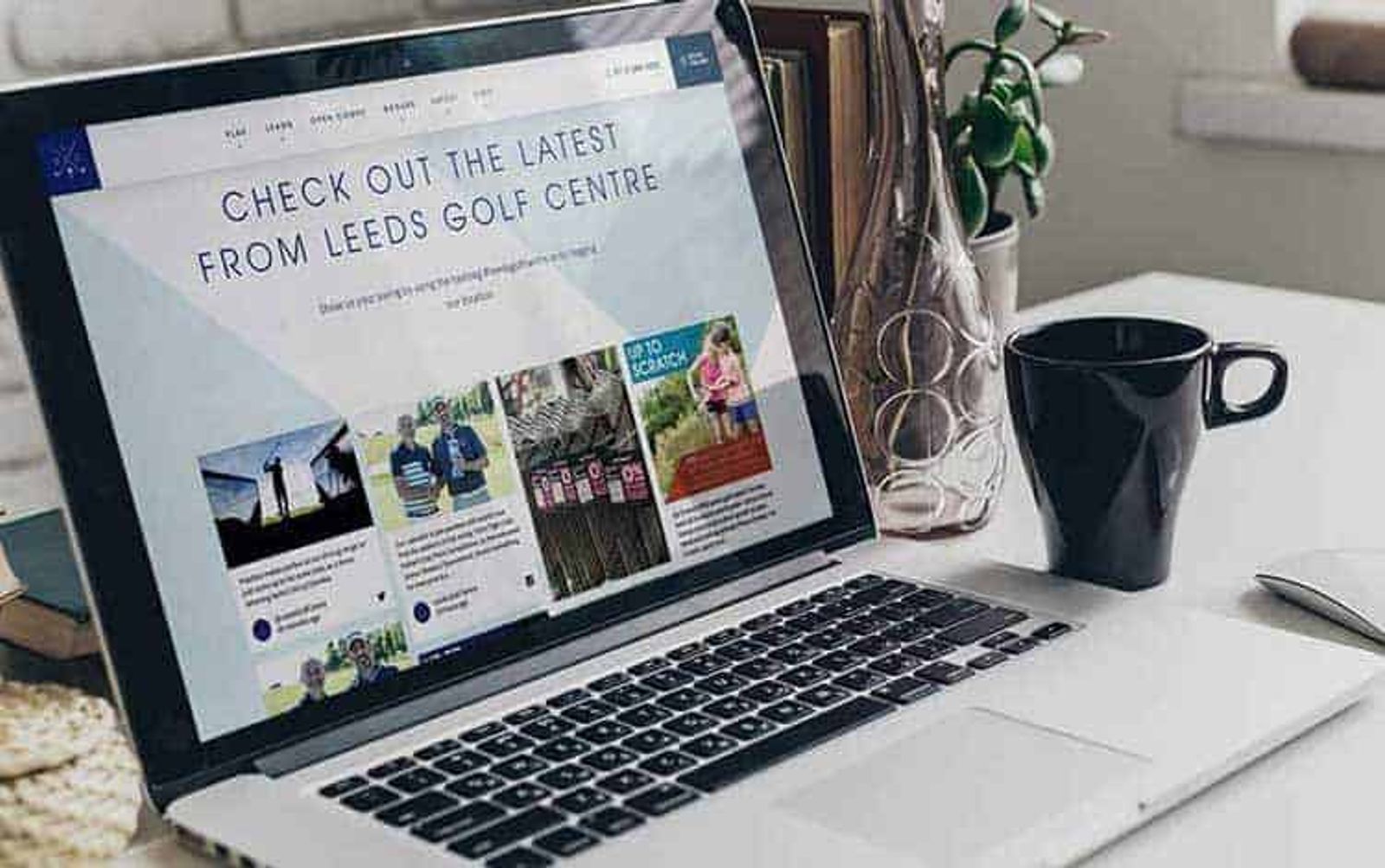 Portátil sobre un escritorio con una página web que muestra una cuadrícula de contenido social de Leeds Golf Centre.