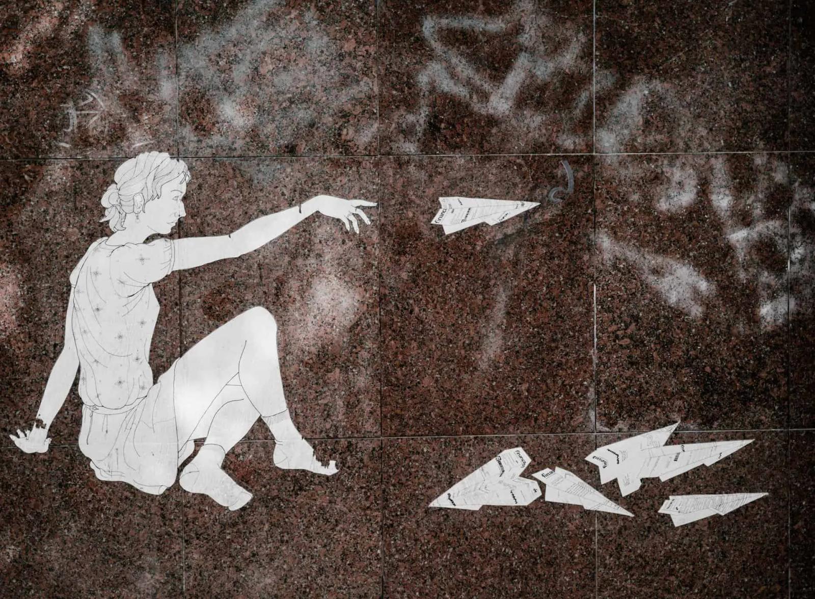 Line-art illustration of a seated figure throwing paper airplanes across a stone floor