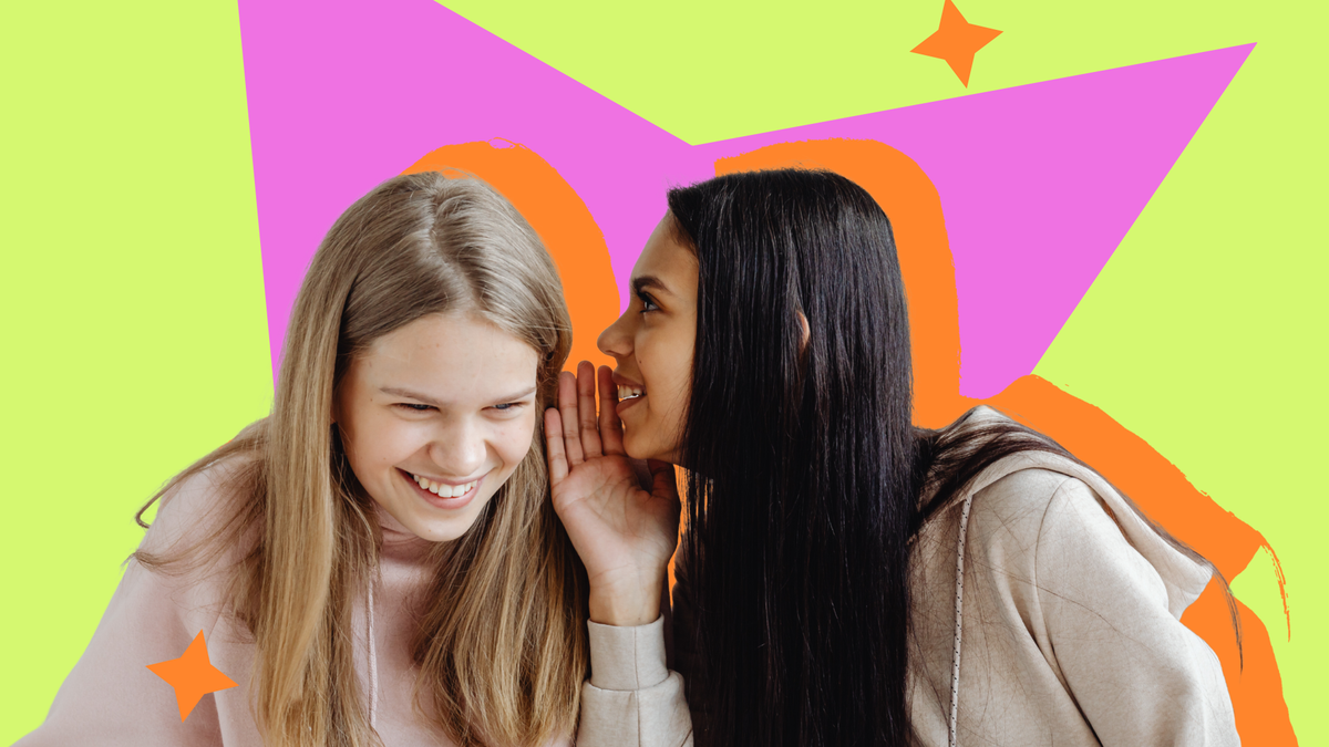 Two young women in pastel hoodies, one leaning in to whisper to the other against a bright graphic backdrop.