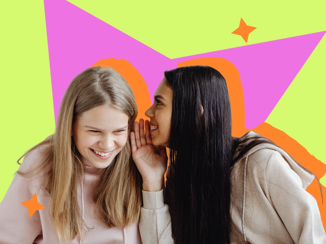Two young women in pastel hoodies, one leaning in to whisper to the other against a bright graphic backdrop.
