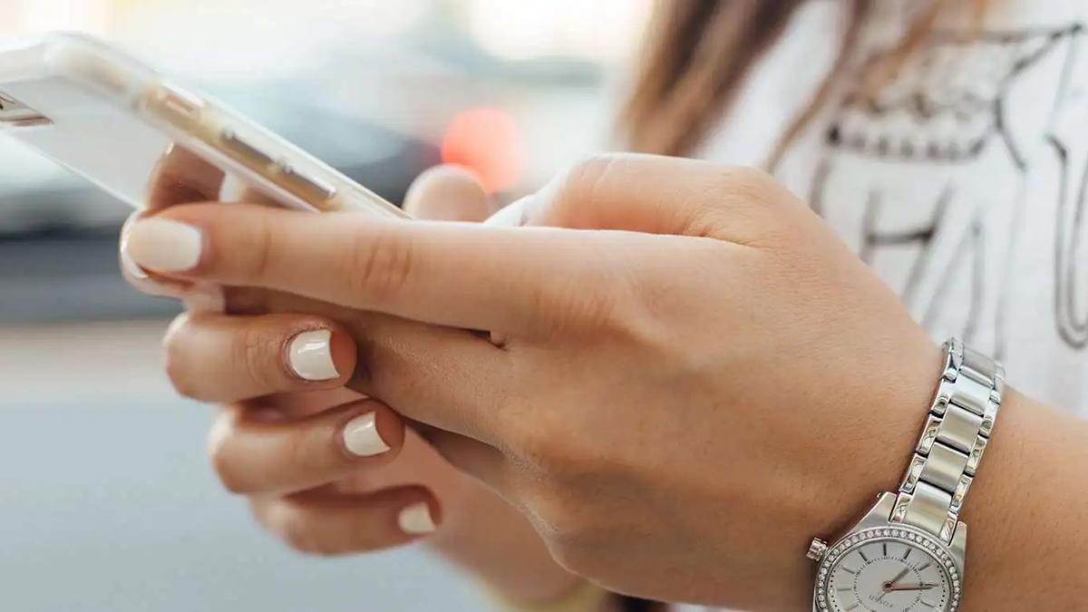 Close-up of a woman's hands holding a smartphone with a clear case