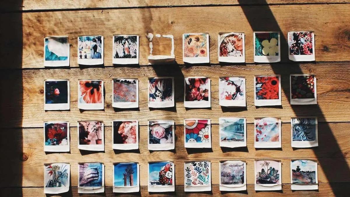 Grid of colorful polaroid photos pinned to a wooden wall in rows