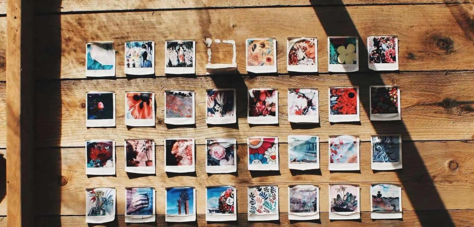 Grid of colorful polaroid photos pinned to a wooden wall in rows