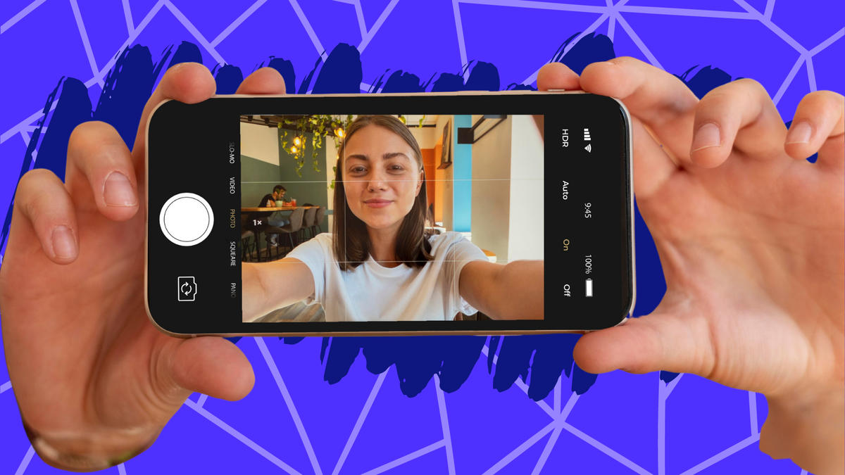 Hands hold a smartphone showing a smiling woman taking a selfie in a cafe, with UI elements visible.