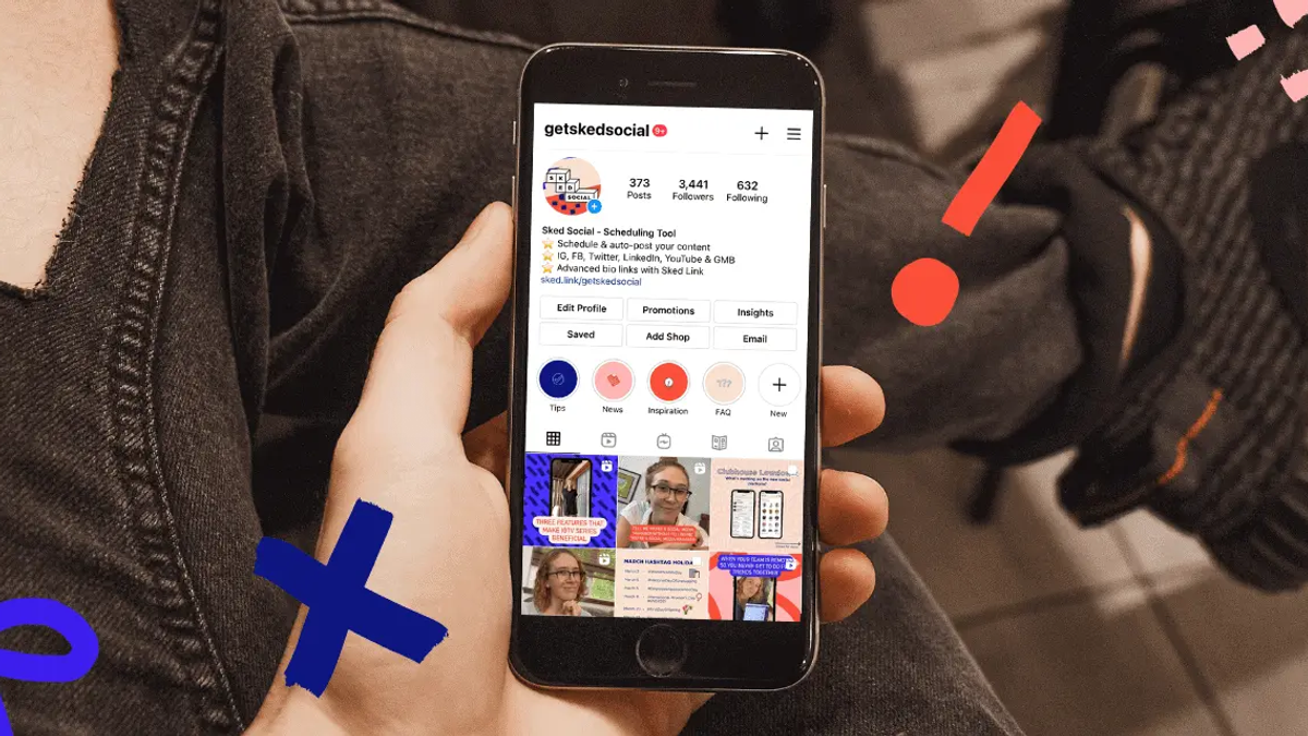 Person holding a black smartphone displaying an Instagram profile, with abstract blue and red shapes around it.