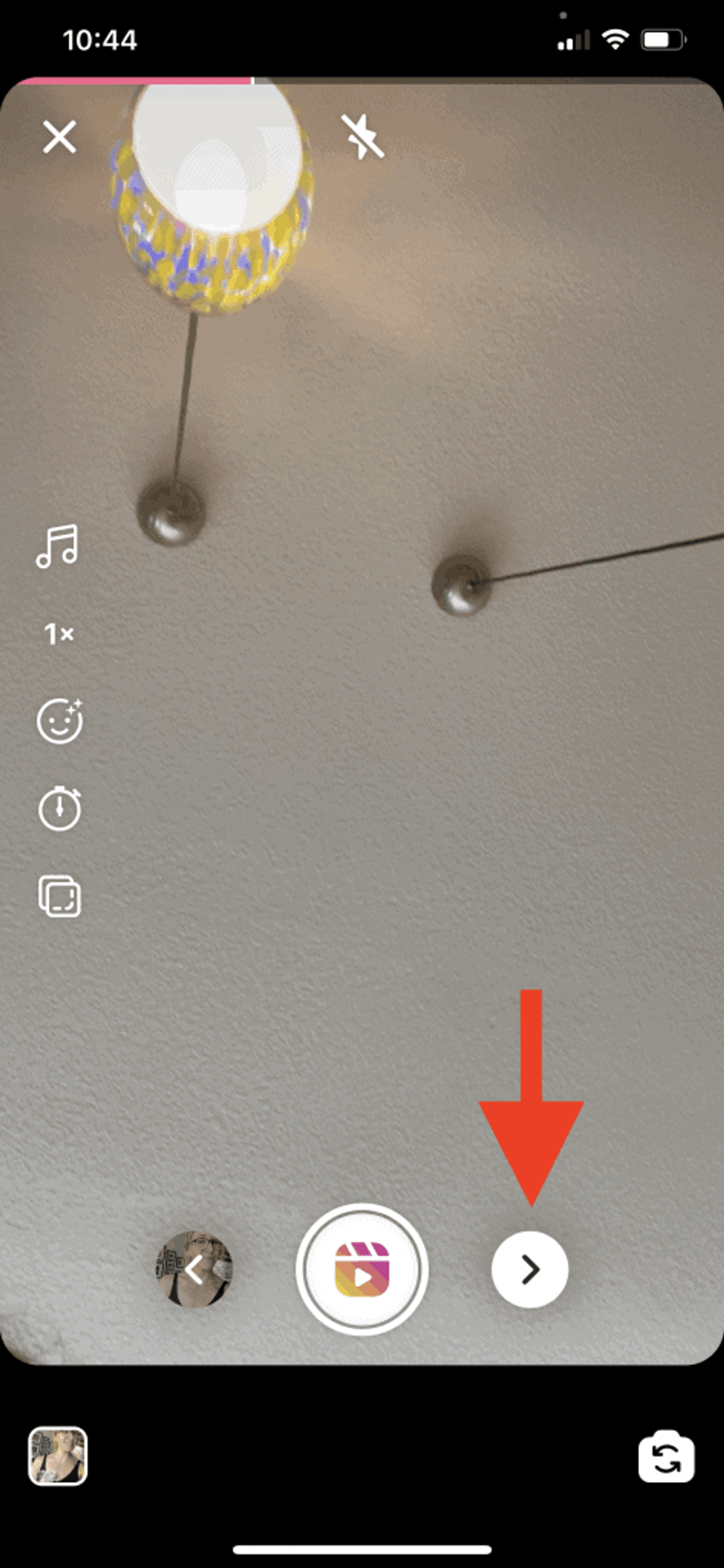 Captura de pantalla de un Reel de Instagram en proceso de creación. Un video ha sido añadido y una flecha roja apunta a la flecha que lleva al usuario a la siguiente página de edición del Reel.