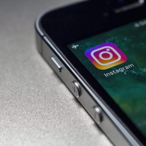 Primer plano del borde de un smartphone con el icono de la app de Instagram en la pantalla de inicio