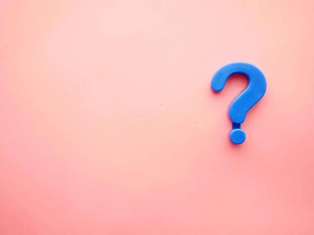 A blue 3D question mark on a plain pink background