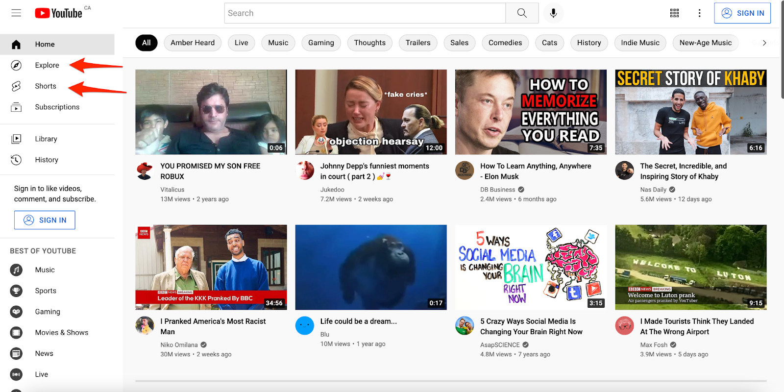Página de inicio de YouTube con flechas señalando las secciones Explorar y Shorts en el menú lateral.