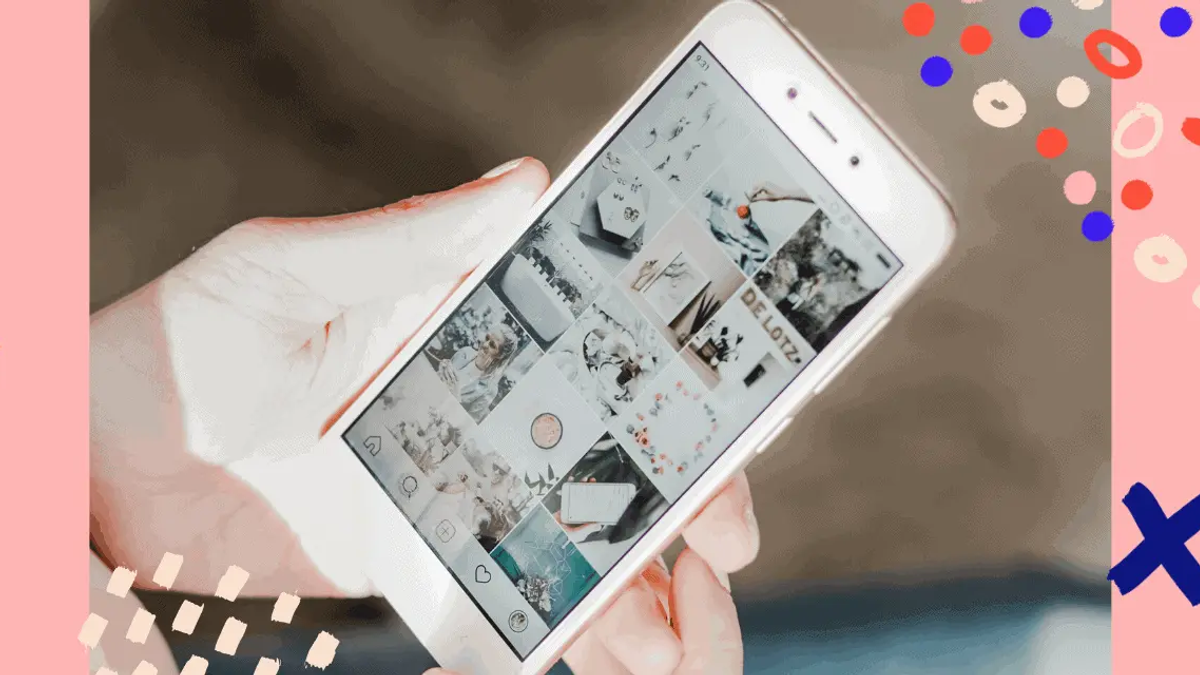 Hands holding a white smartphone displaying an Instagram grid with various images, on a pink background with colorful shapes.