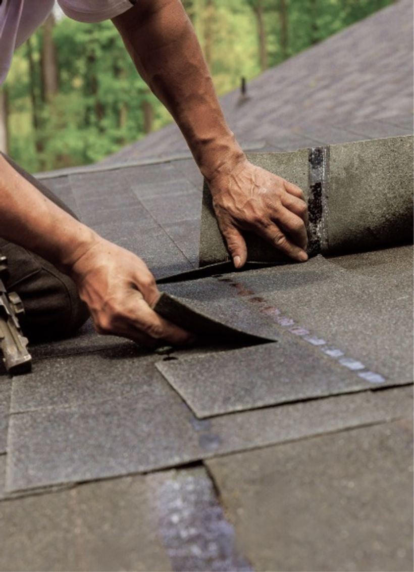 Roofer installing shingles on a residential roof