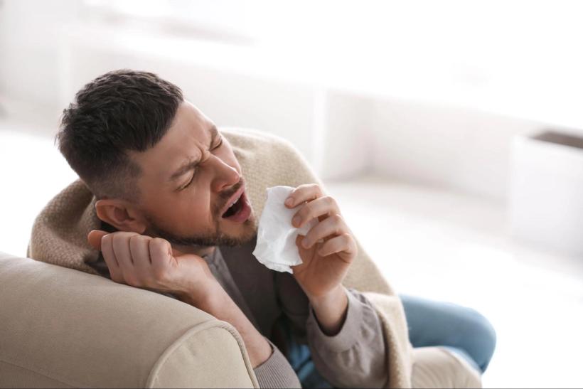 A man mid-sneeze