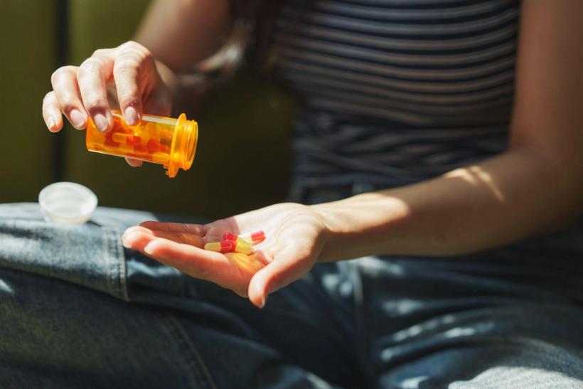 Woman pouring out prescription pills.