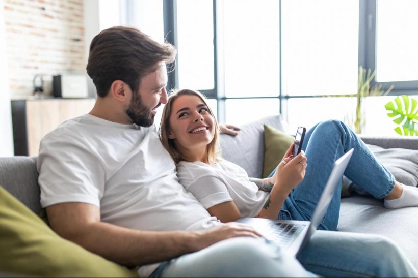 A couple looking at a phone smiling at eachother