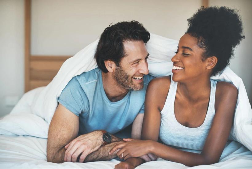 A couple in bed laughing