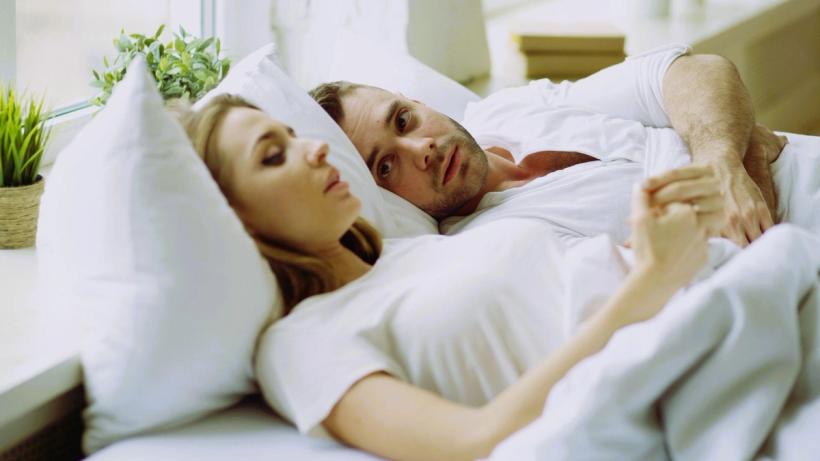 Couple discussing chlamydia status in bed