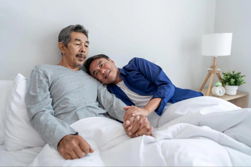 A couple relaxing and cuddling in bed