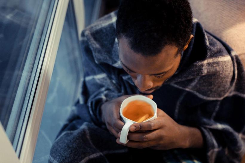 Man drinking tea for his sore throat