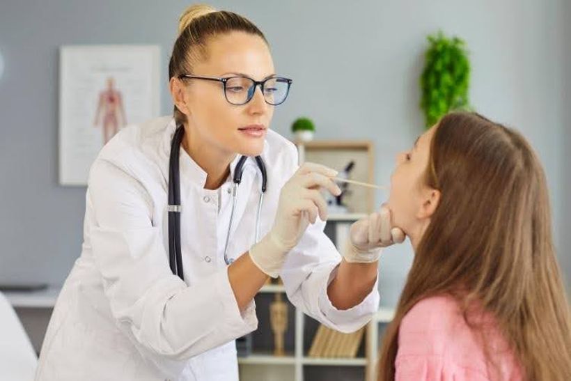 Doctor performing a strep throat swab test.