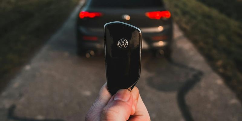 Bilnøkler som holdes opp foran en bil på en landevei.