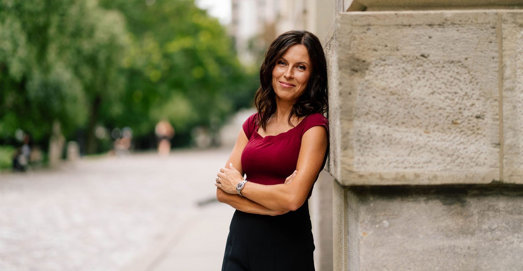 A lawyer standing against a stone wall outdoors