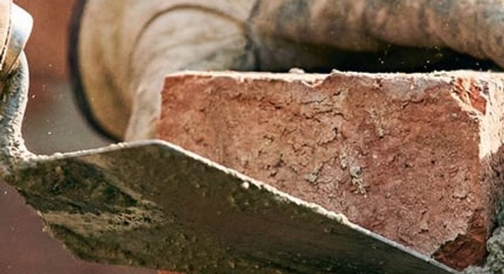 An Automatic Masonry crew working on a stone exterior