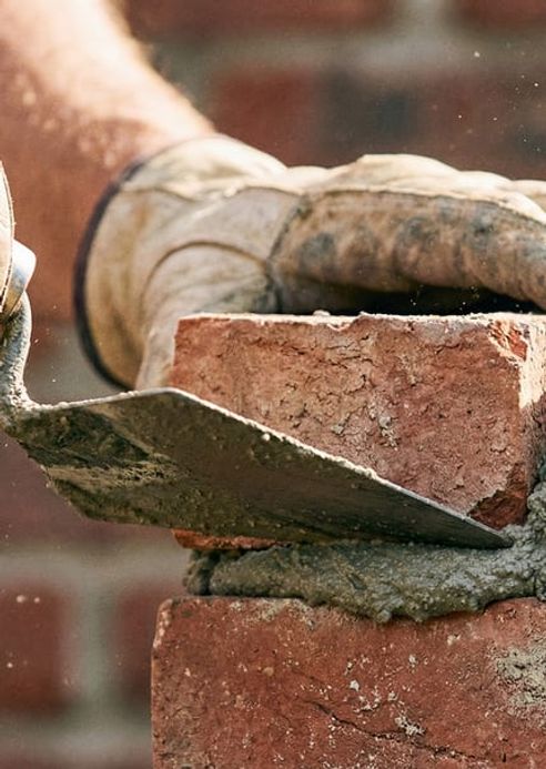 An Automatic Masonry crew working on a stone exterior