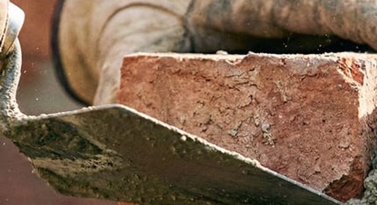 An Automatic Masonry crew working on a stone exterior