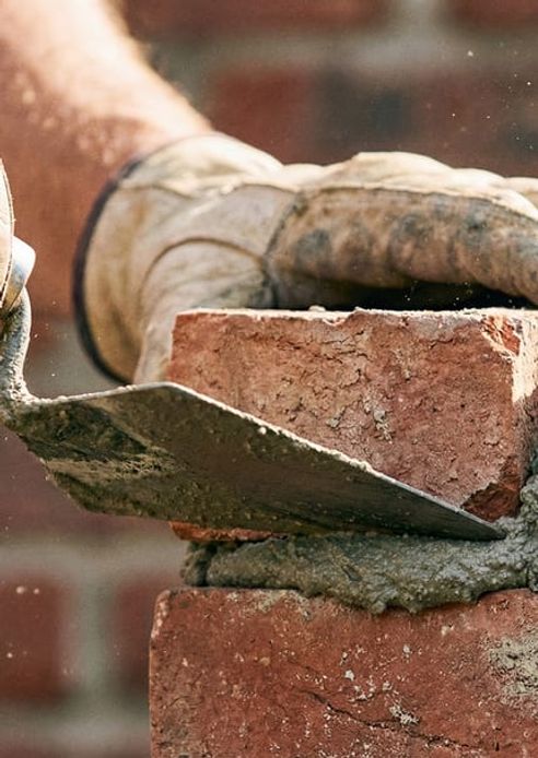 An Automatic Masonry crew working on a stone exterior