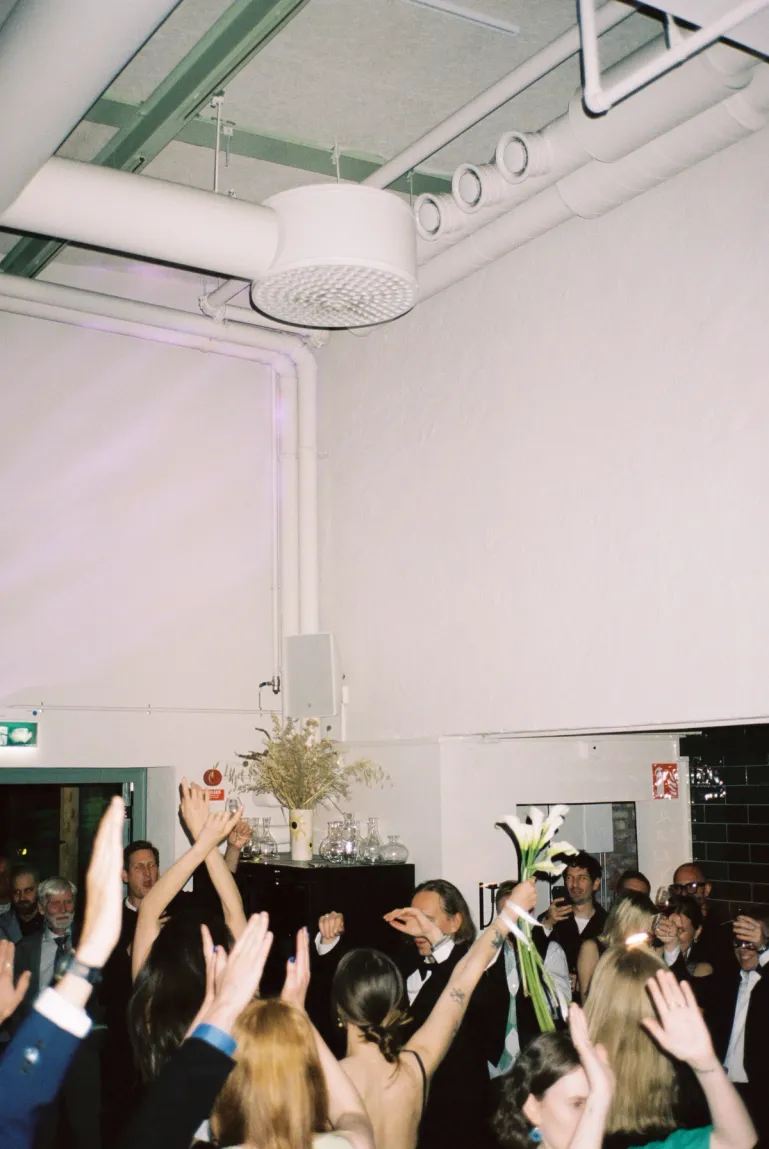 people dancing in the dining room of aster with glasses held high