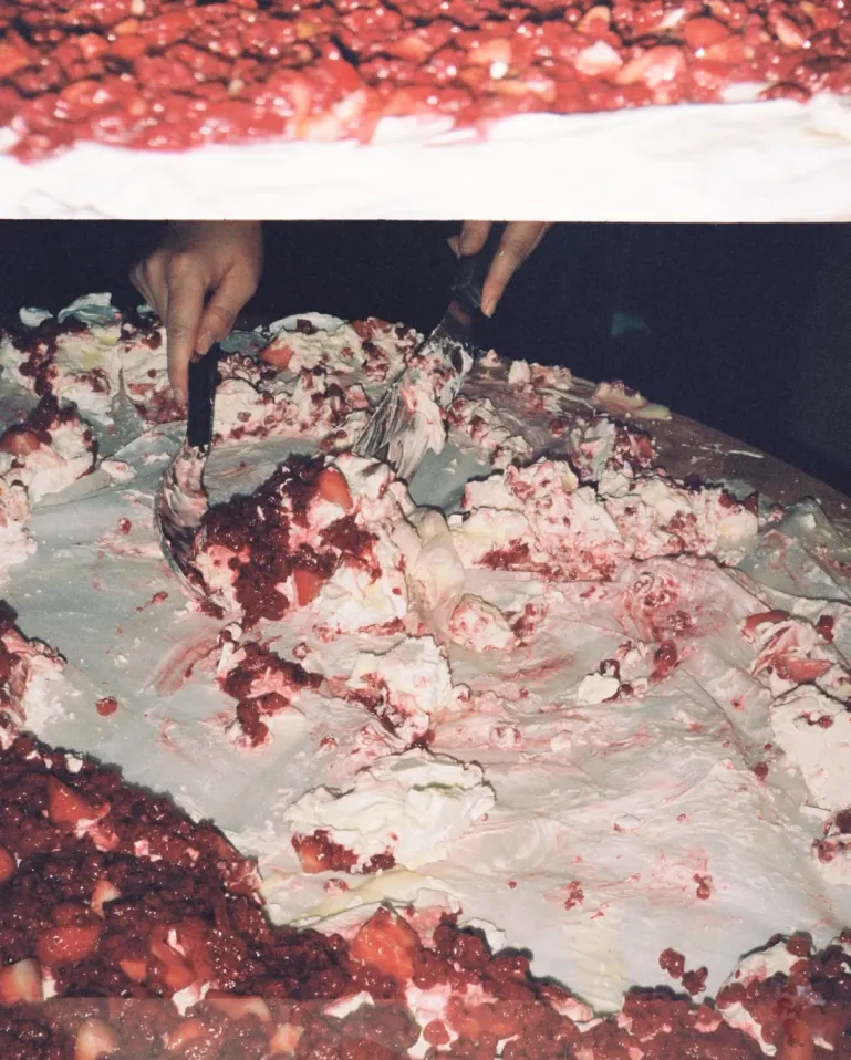 hand digging in to a really big strawberry pavlova