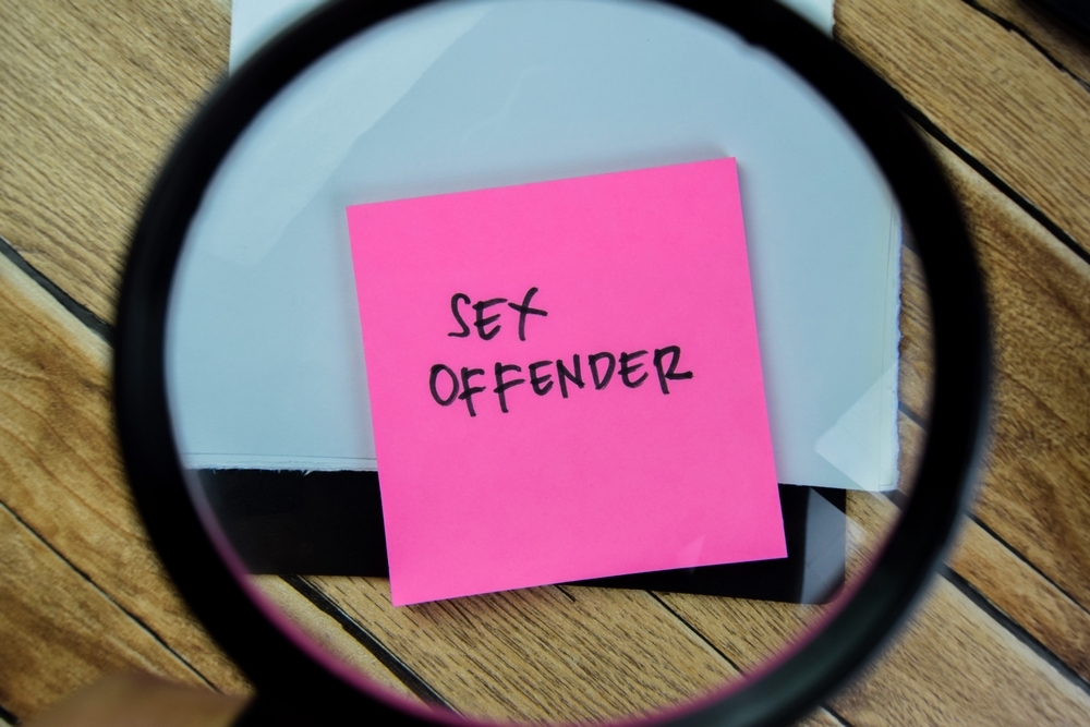 Image A magnifying glass highlighting a note labeled “sex offender,” symbolizing the impact of sex offender registration in Maryland.