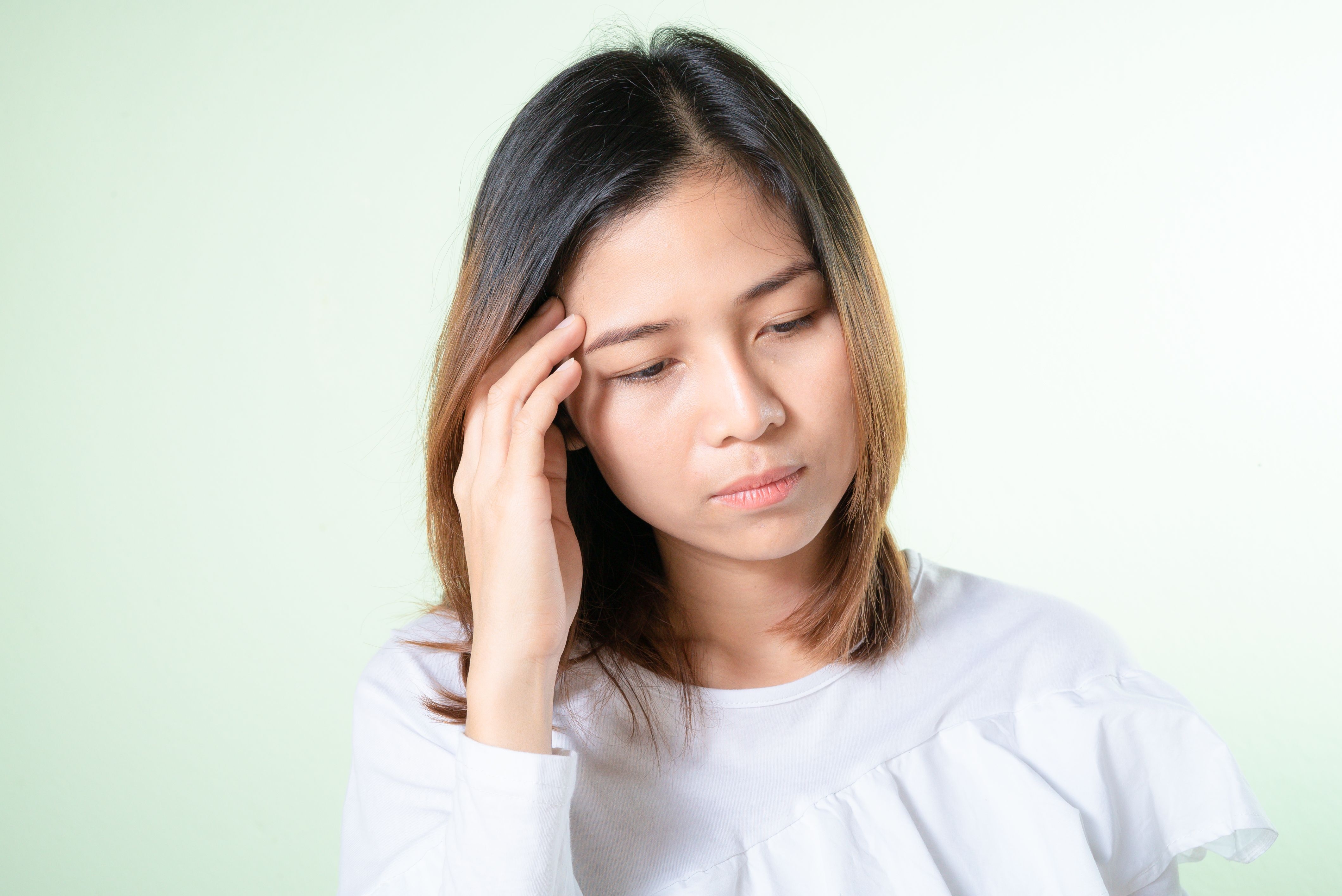 Image Woman holding her head with a headache, showing delayed concussion symptoms after a Maryland car accident