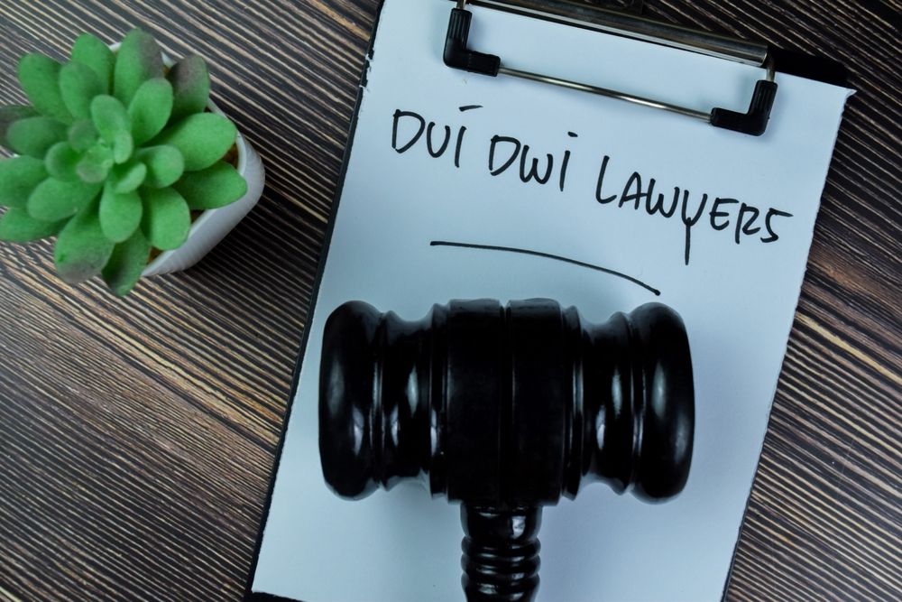 A legal gavel and clipboard with DUI DWI Lawyers written on it, illustrating the professional representation required to protect a Maryland driving record from a permanent DUI entry.