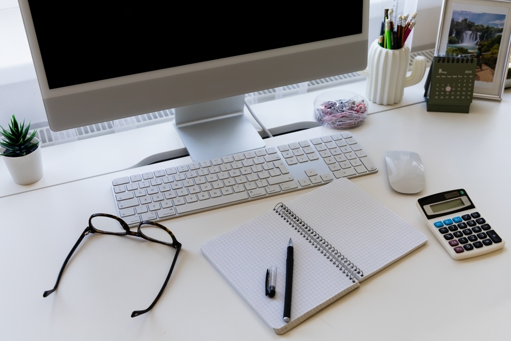 Image A computer, notebook, calculator, and glasses on a desk, representing the digital evidence at the center of a Maryland child pornography investigation.