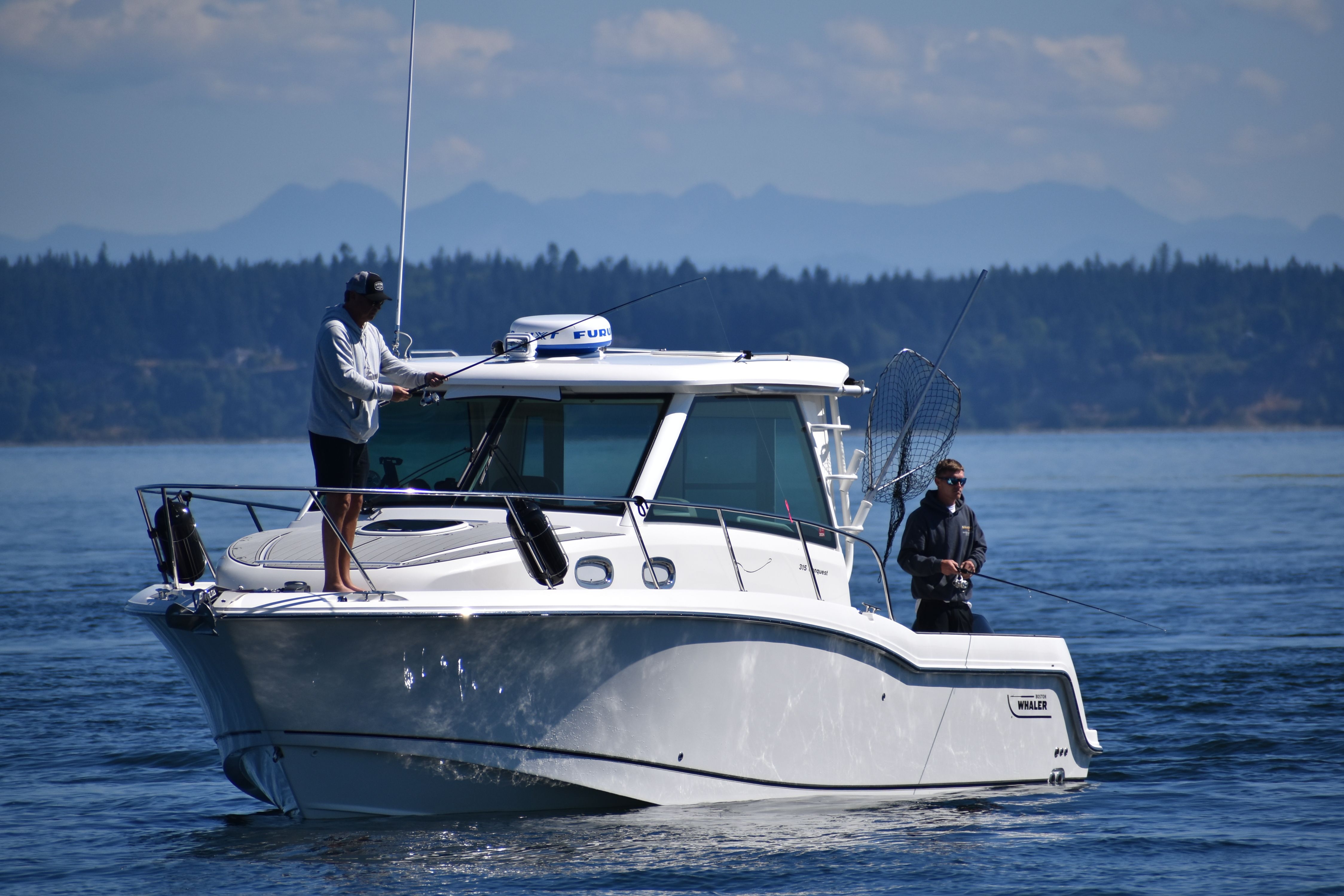 Image Two men fishing from a white boat on open water, representing boating activity during the Huk Big Fish Classic in Ocean City, Maryland