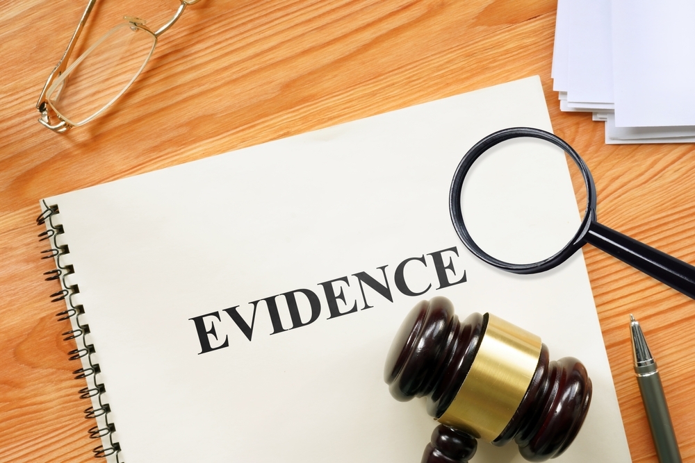 Image Legal evidence folder on a desk with a magnifying glass, gavel, and glasses, symbolizing digital evidence review in a Maryland sex crime case.