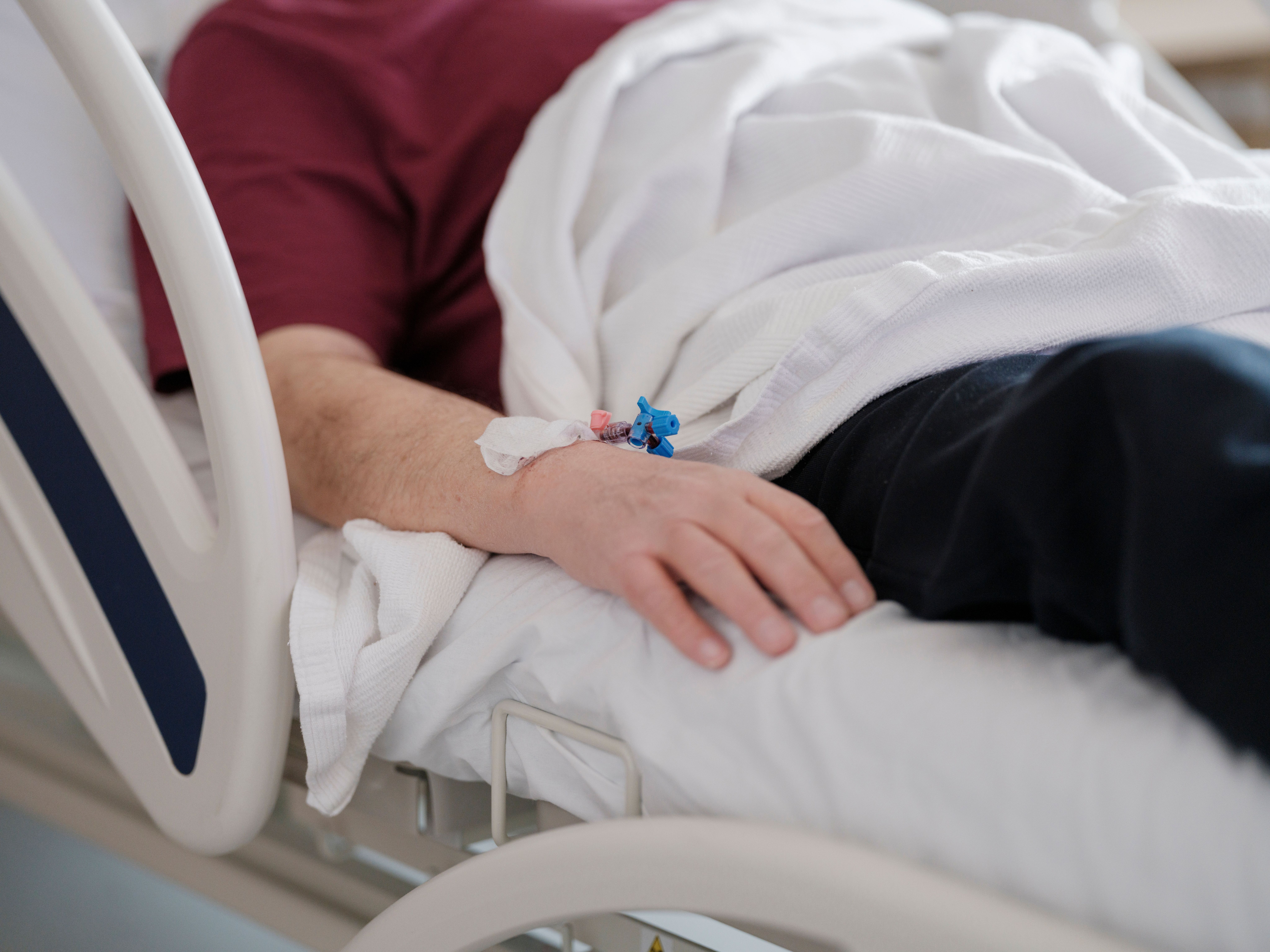 Hospital patient resting in bed with an IV line in the hand, illustrating a missed sepsis diagnosis in a Maryland emergency room.