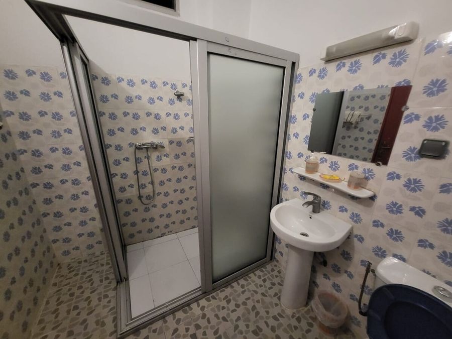 Salle de bain avec douche, lavabo et carrelage floral