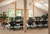 Breakout-Raum mit langem Holztisch, Pflanzen und Telefonbox im Patch.Work Seeon, Chiemgau