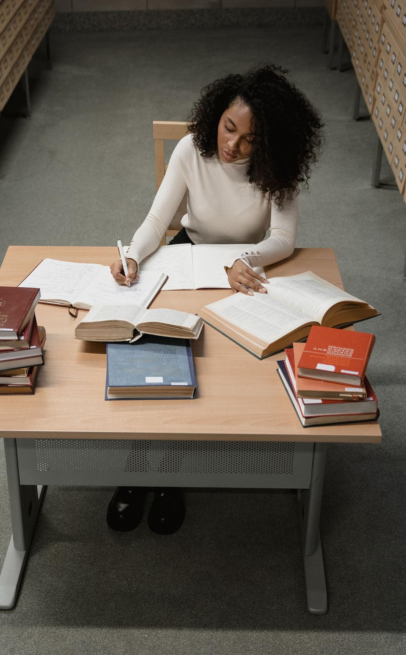 A records officer at work between walls of archive drawers.