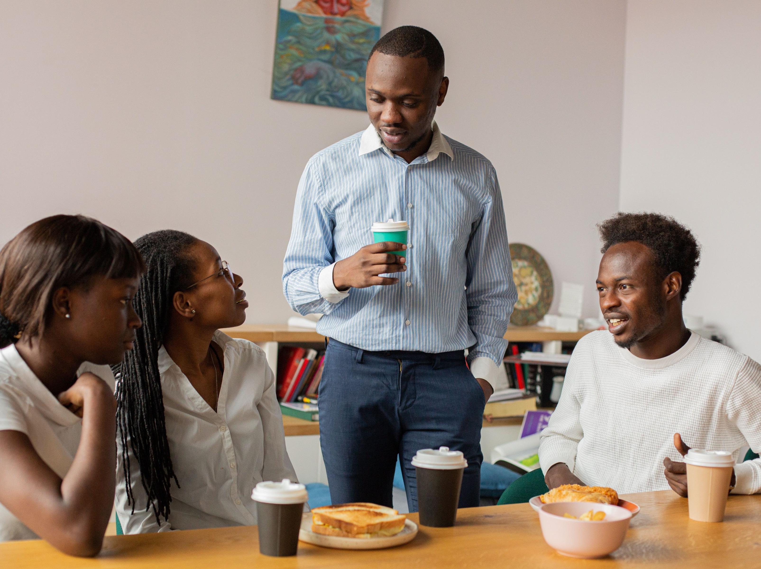 Colleagues talking over coffee at a team break.