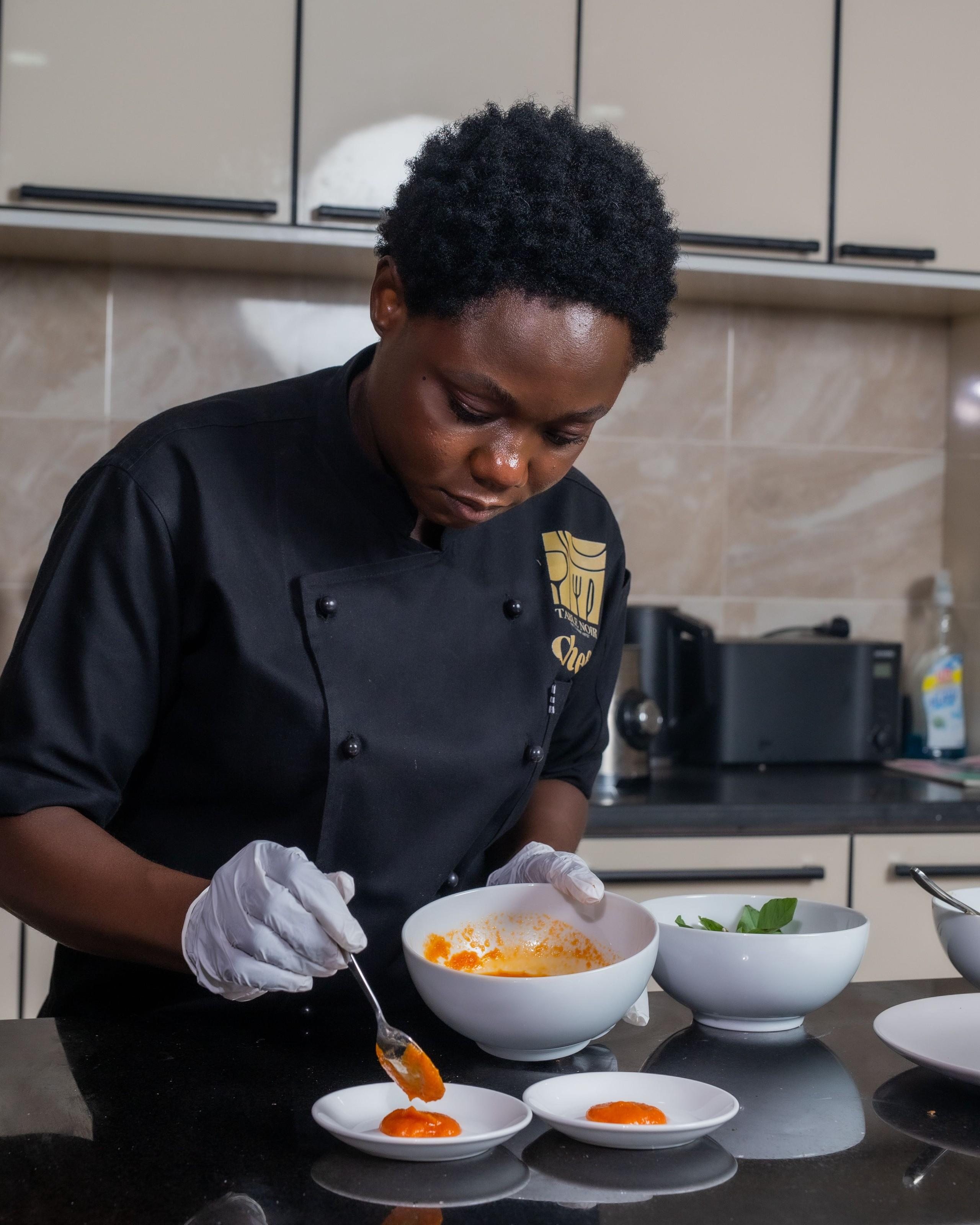 A chef plating sauce samples in a test kitchen.