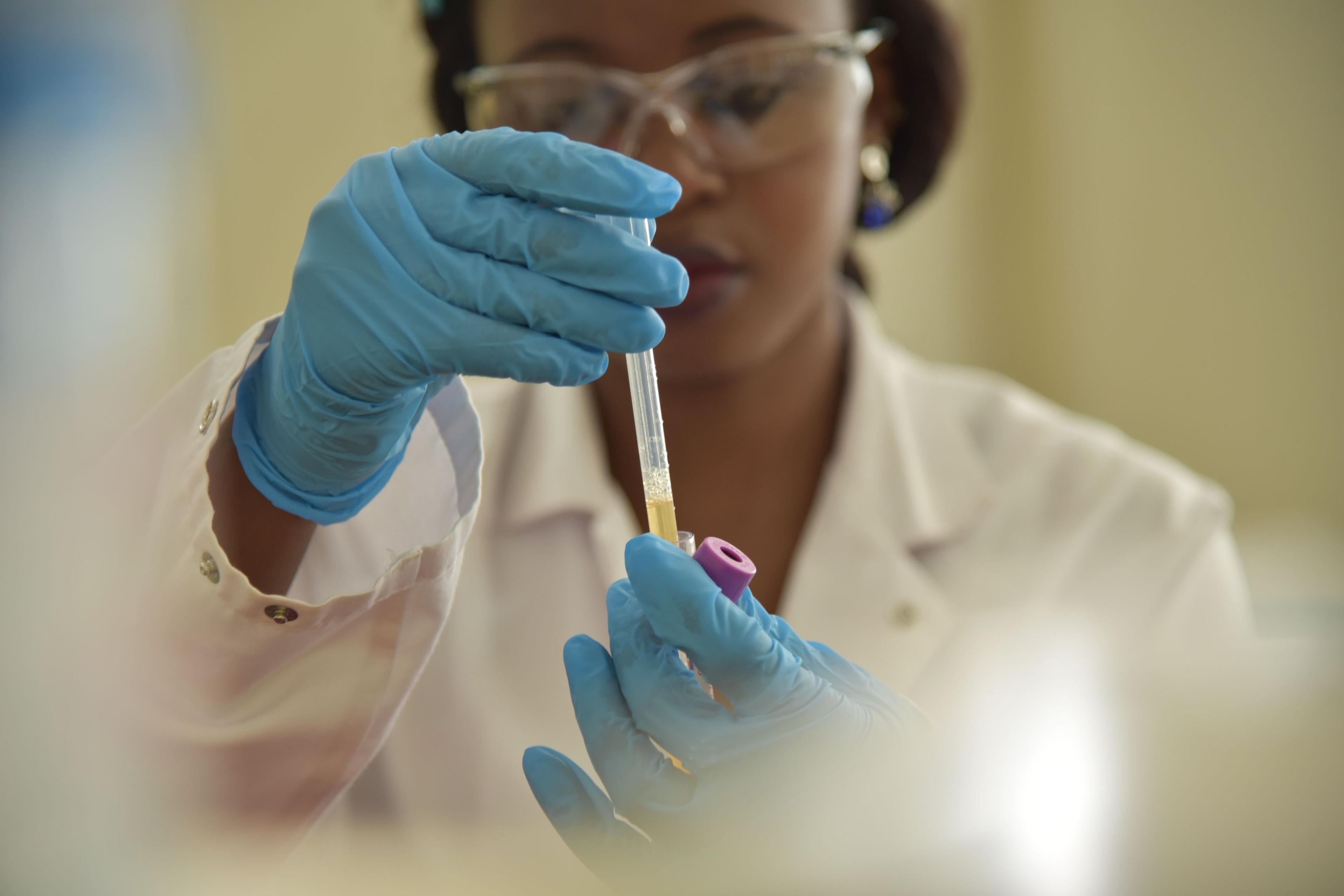 A scientist checking a sample tube in the lab.