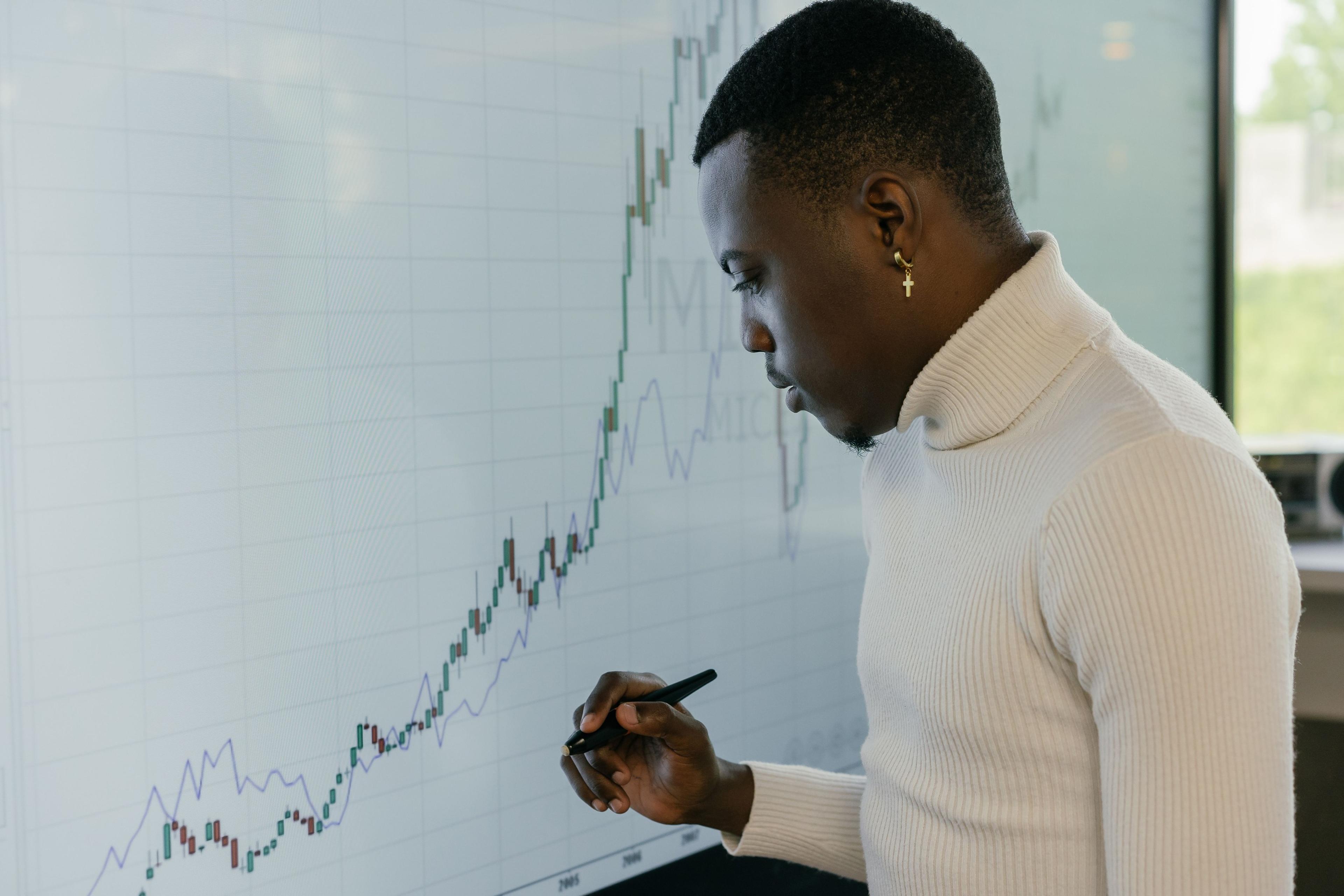 An analyst marking up a chart on a glass wall.