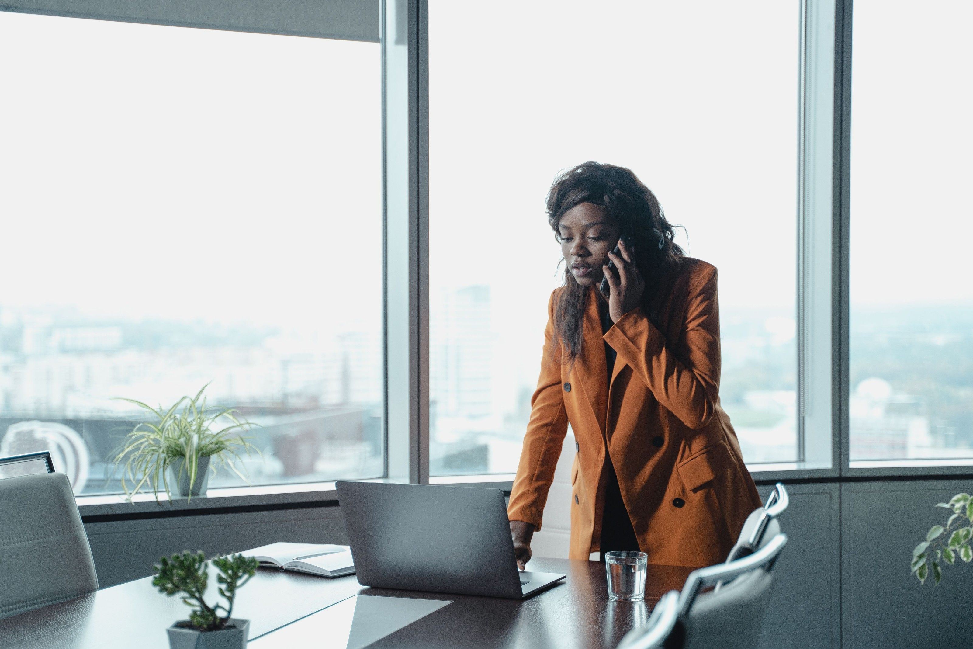 An investment professional on a call by high-rise windows.