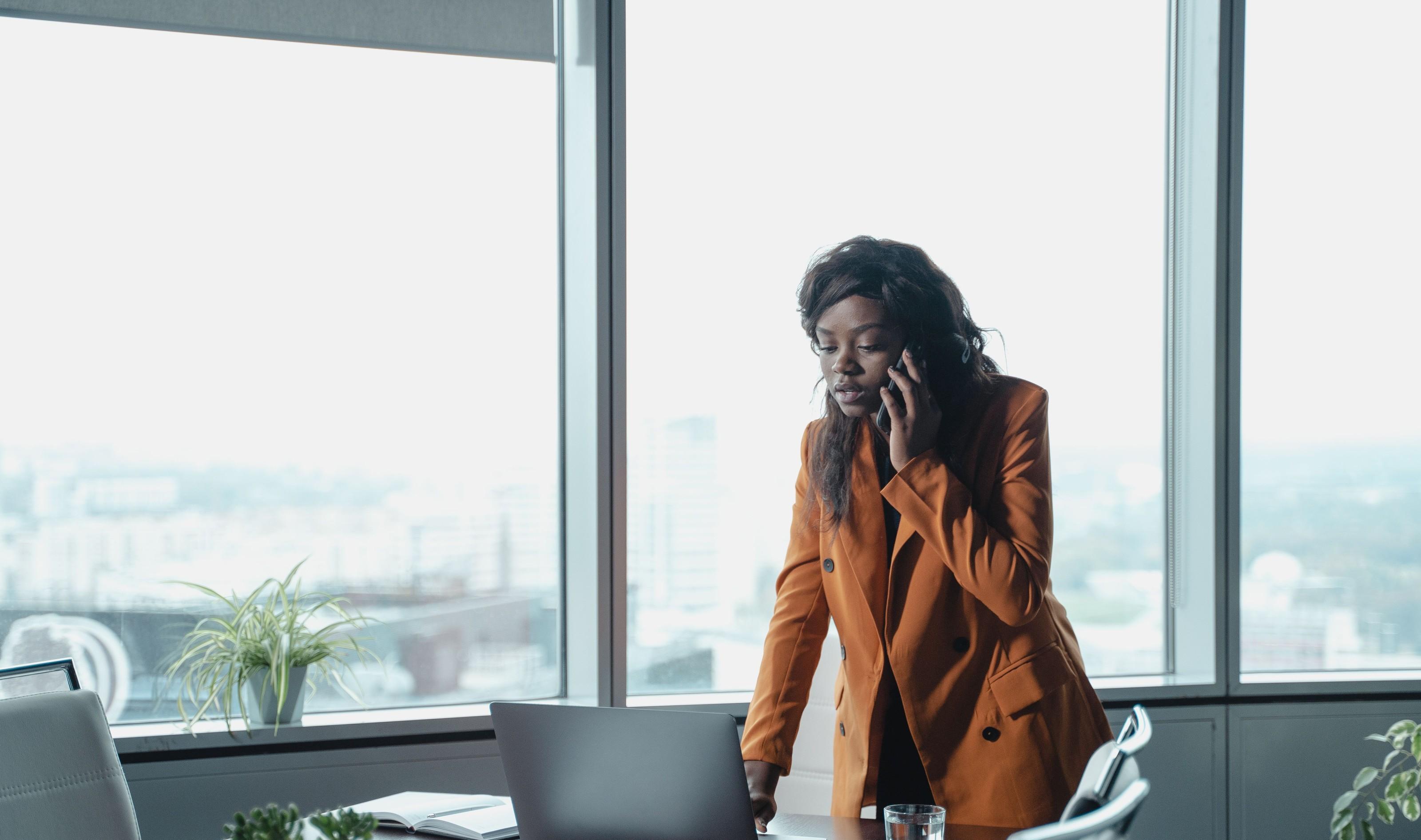 An investment professional on a call by high-rise windows.
